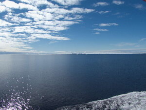 Some distant icebergs are truly massive, perhaps having flipped over, resembling distant moutain ranges.